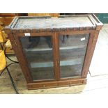 An oak, twin door glazed shop display cabinet with interior shelves,