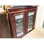 A stained mahogany two door glazed cabinet with later added hand painted sweet decals