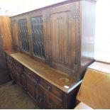 An oak Old Charm style sideboard with four drawers and lead glazed doors over two cupboard doors