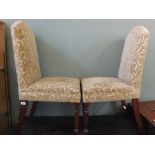 A set of four mahogany dining chairs with beige floral upholstery on fluted legs