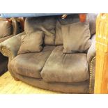 An American brown suede and brass stud upholstered two seater sofa and matching armchair