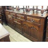 A modern oak long sideboard with four drawers over a central drawer and door flanked by two