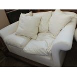 A modern uncovered three seater sofa with cushions