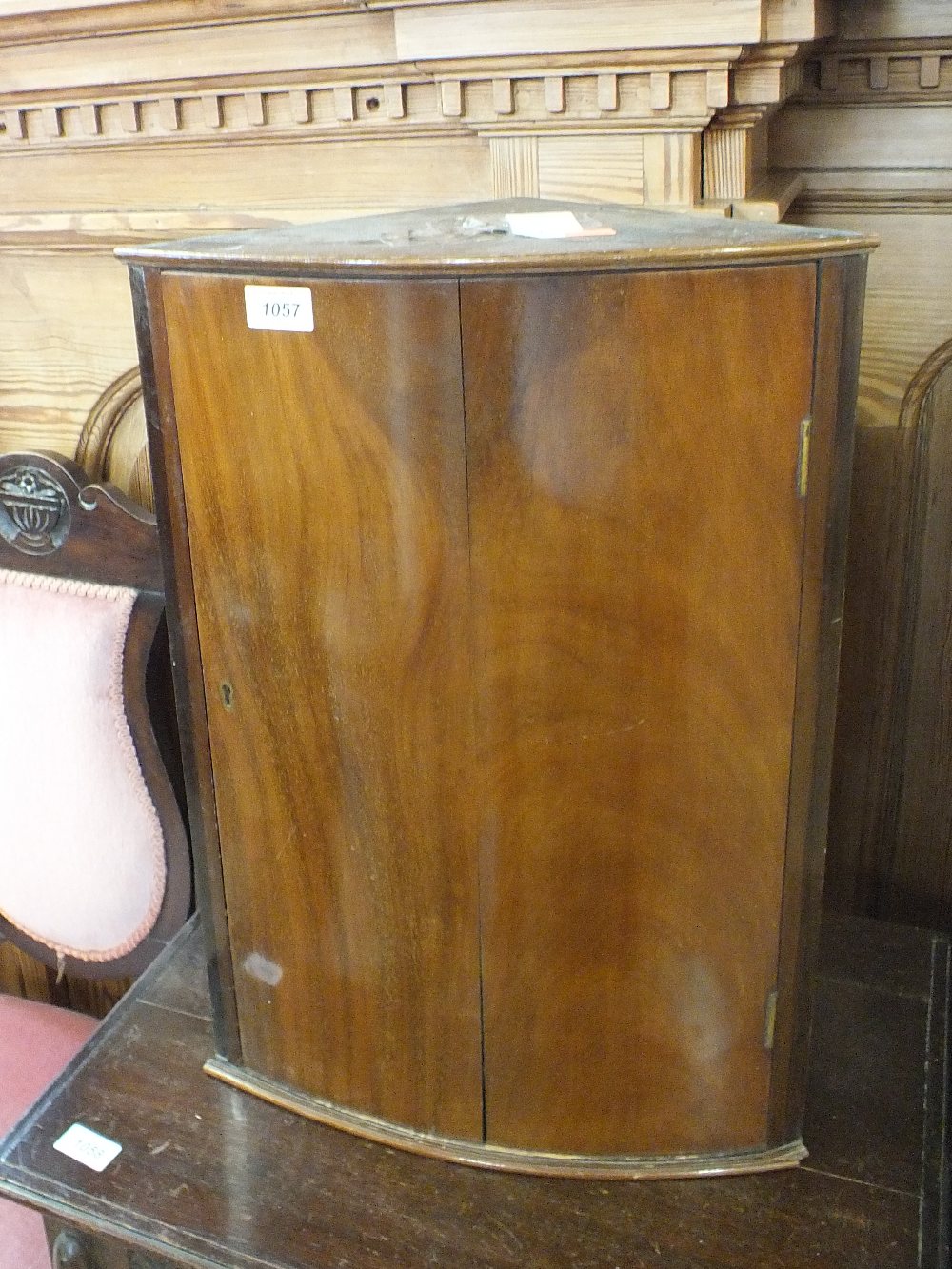 A small mahogany bow fronted single door corner cupboard