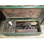 A green painted pine carpenters tool chest with a selection of tools including planes,