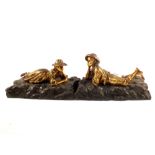 A pair of gilt metal figures of reclining boy and girl
