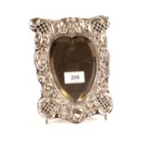 A silver heart shaped easel mirror with later added feet,