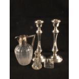 A pair of silver candlesticks (one as found),