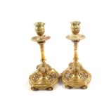 A pair of 19th Century aesthetic movement brass candlesticks ornately cast with open work and