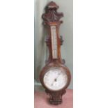 A carved oak aneroid barometer