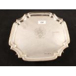 A shaped silver salver with family crest,