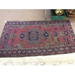 A Persian maroon ground rug with multiple medallions,