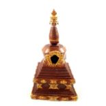 A Tibetan bronzed and polychrome gilt stupa,