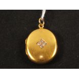 A 15ct gold photo locket set with four small diamonds (dents to back)