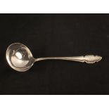 A silver soup ladle with family crest,