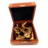 A cased brass model of a sextant with 'a history of the navigators sextant'