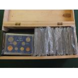 A wooden case containing GB and foreign cased coin sets