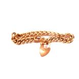 A 9ct gold curb link bracelet with heart shaped padlock clasp