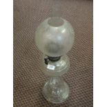 A cut glass oil lamp with etched globe