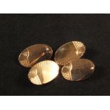 A pair of 9ct gold oval cufflinks with engraved decoration