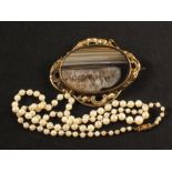 A string of cultured pearls with a 9ct gold clasp in bow form,