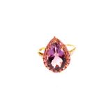 A 9ct gold ring set with large pear shaped amethyst, pink stone surround and diamond set shoulders,