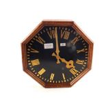 A large octagonal oak electric wall clock,