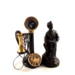 A reproduction brass and Bakelite stick telephone plus a figure of a miner