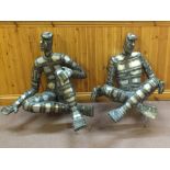 Two metal sculptures by Bob Waters of cross legged figures,