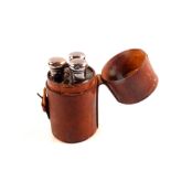 Three glass and silver topped scent bottles in fitted leather travel case