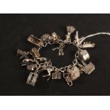 A silver charm bracelet set with multiple silver and white metal charms