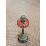 A brass column oil lamp with cut ruby bowl