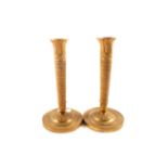 A pair of early 19th Century French gilt brass candlesticks with engine milled decoration to the