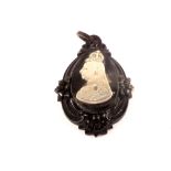 A Victorian jet pendant with applied white metal bust of Queen Victoria