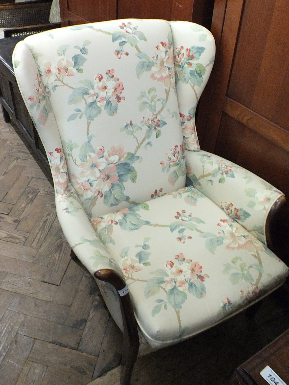 A modern Plumbs wingback armchair with apple blossom upholstery