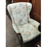 A modern Plumbs wingback armchair with apple blossom upholstery