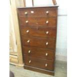 A narrow mahogany chest of six graduated drawers with brass handles and two mahogany dining chairs