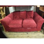 A modern dark red upholstered two seater sofa