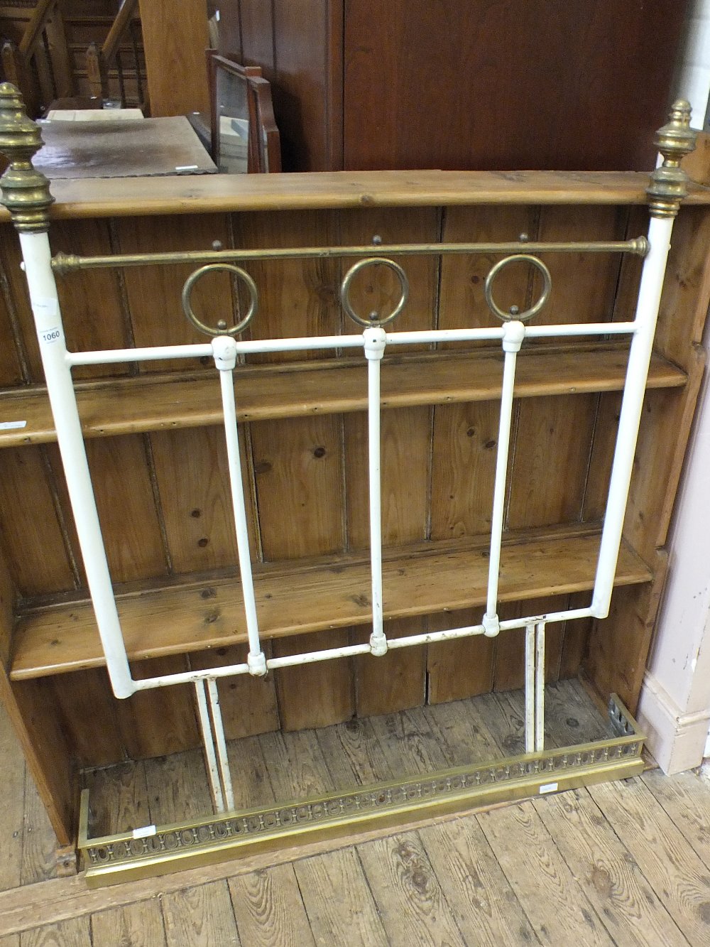 A white painted brass single headboard and brass fender