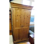 A pine two door wardrobe with matching bedside chest of three drawers