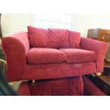 A modern dark red upholstered two seater sofa