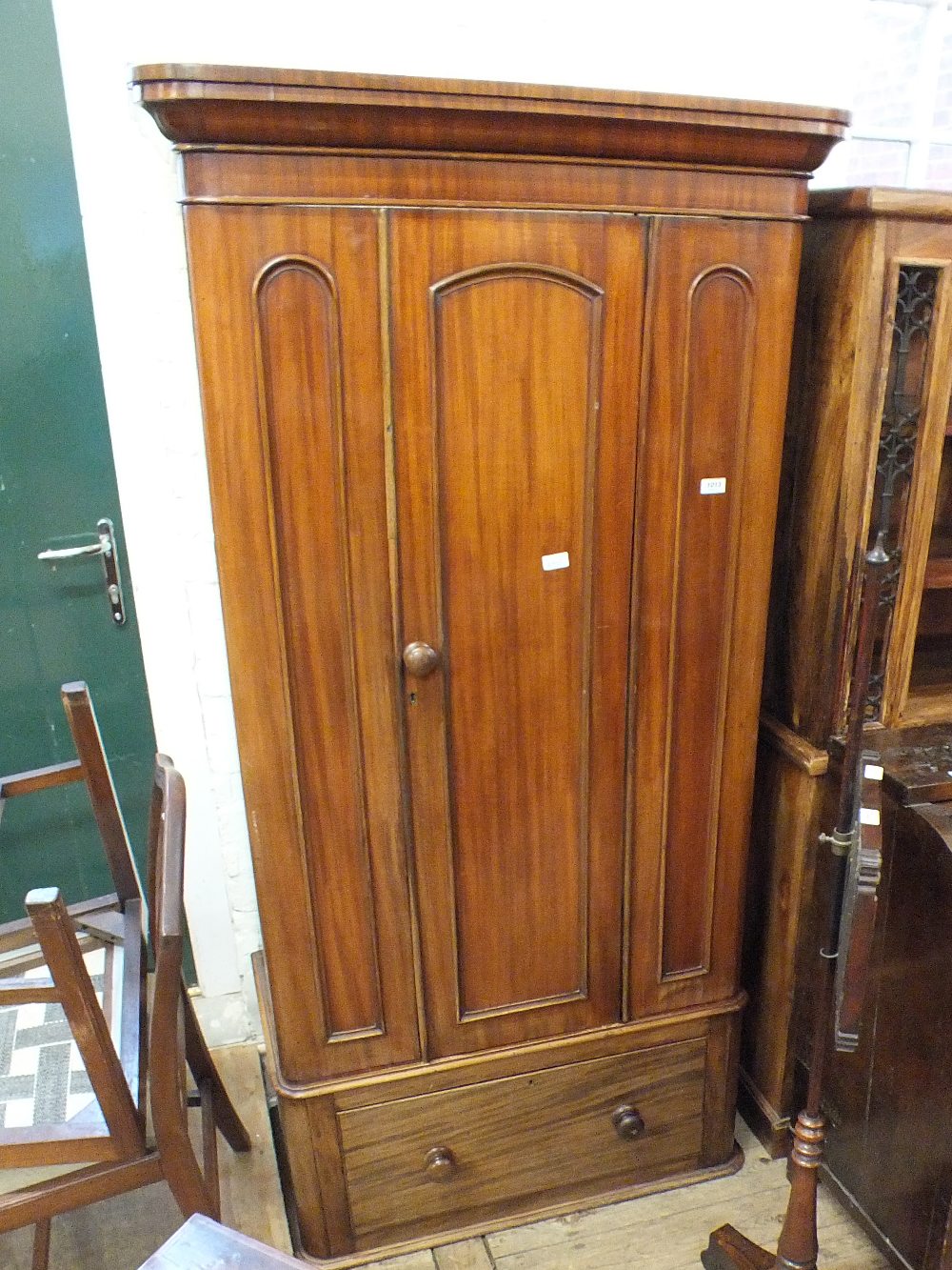 A Victorian mahogany single door wardrobe with single drawer base