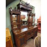 An ornately carved mahogany mirror and shelf back sideboard.