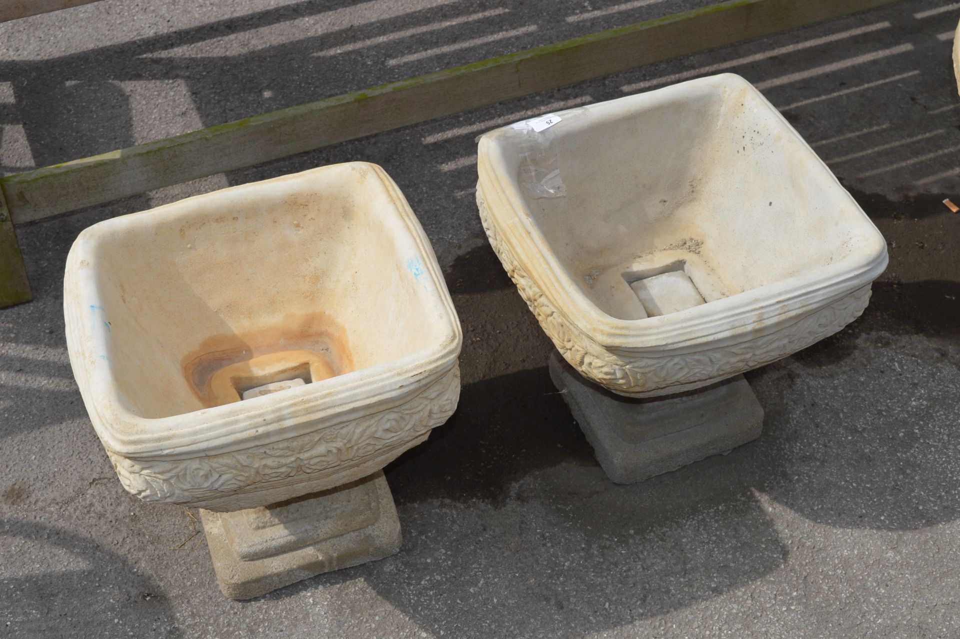 Pair of Reconstituted Stone Rose Patterned Urns on Plinths