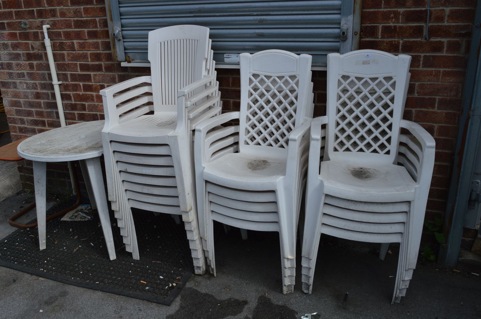 Eighteen White Plastic Garden Chairs and Circular Table