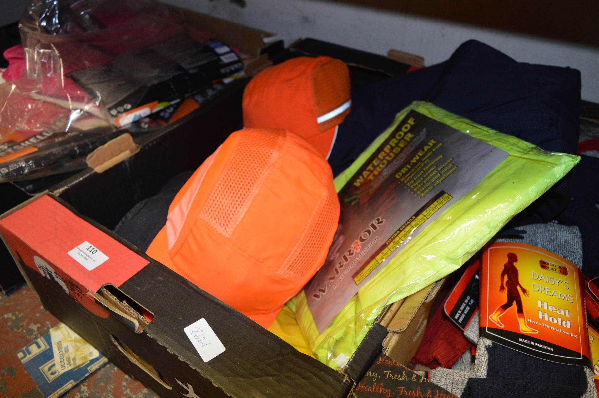 Box Containing Helly Hansen Work Trousers, Hi-Vis Waterproof Trousers and Safety Hats