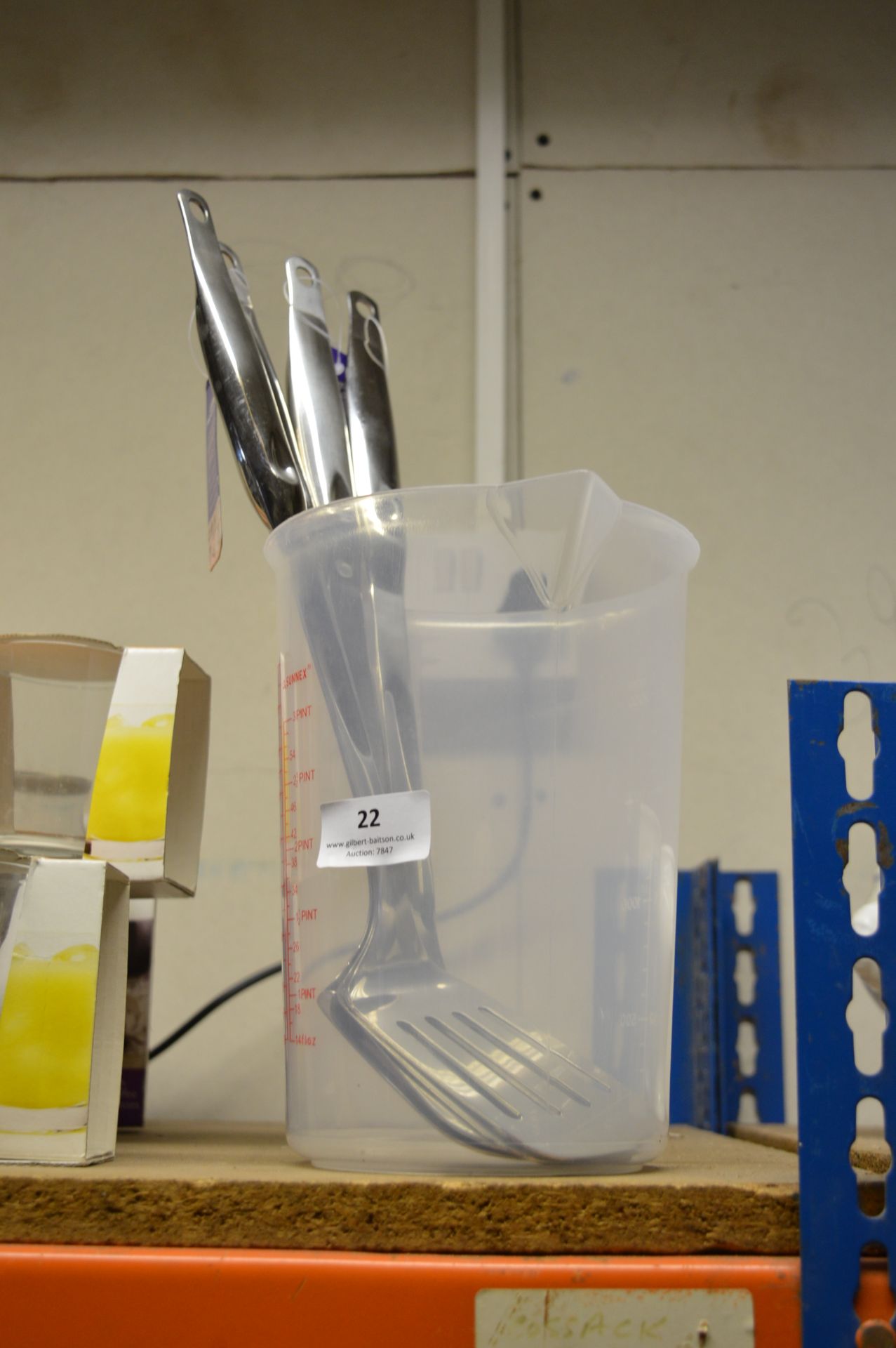 Plastic Jug Containing Four Stainless Steel Fish Slices