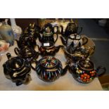 Collection of 12 Black Pottery Gilt & Floral Decorated Teapots