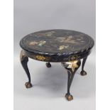 A black Japanned Oriental style circular occasional table, decorated in gilt with figures, etc, on