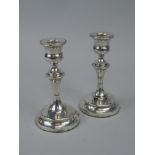 A pair of George V silver candlesticks, with a turned column, and domed foot, Birmingham 1923,